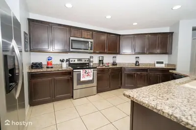 a large kitchen with wooden cabinets and stainless steel appliances at Beautiful vacation home near Disney in Kissimmee