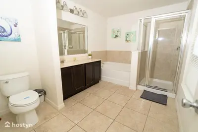 a bathroom with a toilet and a sink and a shower at Beautiful vacation home near Disney in Kissimmee