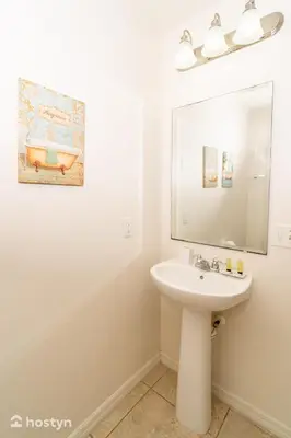 a white bathroom with a sink and a mirror at Beautiful vacation home near Disney in Kissimmee