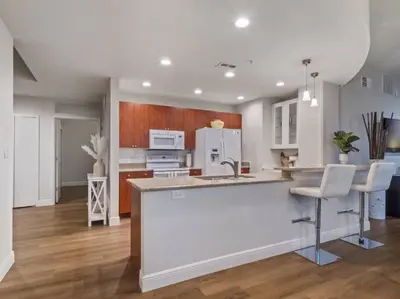 a kitchen with white cabinets and a kitchen island with stools at 4Bedroom/ 2bath 2100sq ft Thorton Park Master Suite in Orlando