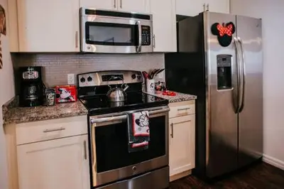 a kitchen with a stove and a stainless steel refrigerator at Family house with amazing themed rooms in Kissimmee