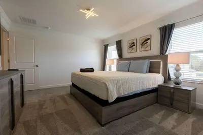 a bedroom with a bed and a dresser and a window at Amazing house near the parks in Kissimmee