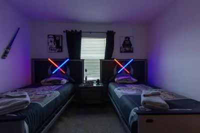 a bedroom with two beds with neon lights on them at Amazing house near the parks in Kissimmee