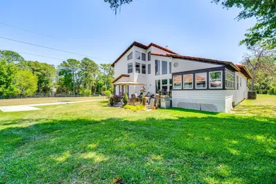 a white house with a large yard at 1-Acre Backyard and Gym Spacious Apopka Escape! in Orlando