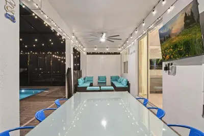 a room with a pool and a table and chairs at 5 Star Exceptional Luxury Villa at Storey Lake mins to Disney in Kissimmee