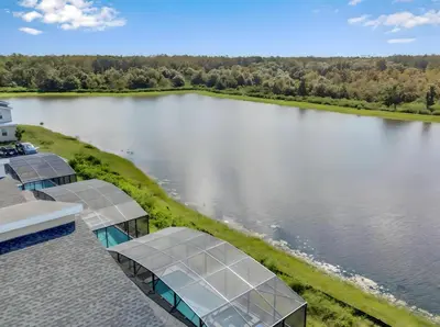 an aerial view of a lake with solar panels on a house at 5 Star Exceptional Luxury Villa at Storey Lake mins to Disney in Kissimmee