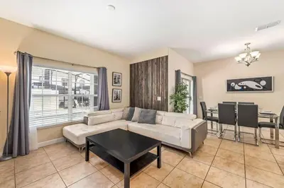a living room with a couch and a table at 9 min to Disney w Pool- 4BD 3BA - FREE Waterpark in Kissimmee