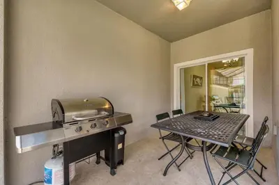 a kitchen with a grill and a table with chairs at 9 min to Disney w Pool- 4BD 3BA - FREE Waterpark in Kissimmee