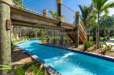 a bridge over a swimming pool in a resort at 9 min to Disney w Pool- 4BD 3BA - FREE Waterpark in Kissimmee