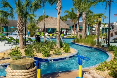 a pool at a resort with palm trees at 9 min to Disney w Pool- 4BD 3BA - FREE Waterpark in Kissimmee