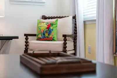 a living room with a chair with a pillow at Private Pool! Big and Stylish House! in Orlando