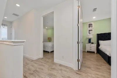 a bedroom with a bed and a door leading into a room at Private Pool! Big and Stylish House! in Orlando