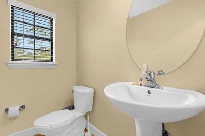 a bathroom with a sink and a mirror and a toilet at Summer Stay - Renovated TownHome by Disney! in Orlando