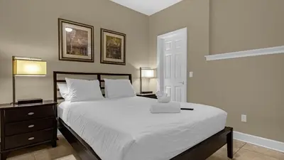 a bedroom with a large white bed and two lamps at Sun, Fun & Summer Getaway - TownHome by Disney! in Orlando