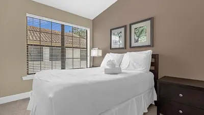 a bedroom with a large white bed and a window at Sun, Fun & Summer Getaway - TownHome by Disney! in Orlando