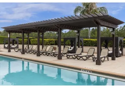 a pergola and chairs next to a pool at Sun, Fun & Summer Getaway - TownHome by Disney! in Orlando