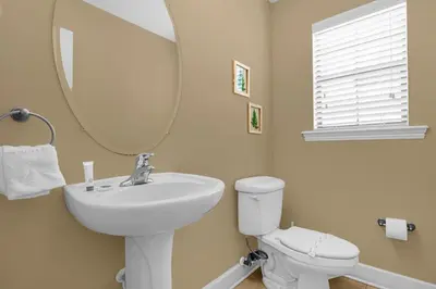 a bathroom with a sink and a mirror and a toilet at Cozy & Elegant 4BR Enchanted Townhouse - 1 Mile to Disney with Resort Pool, Gym, & Jacuzzi in Orlando