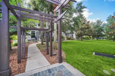 a garden with a pergola and a lawn at Cozy & Elegant 4BR Enchanted Townhouse - 1 Mile to Disney with Resort Pool, Gym, & Jacuzzi in Orlando