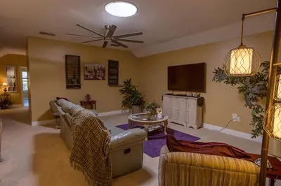 a living room with a couch and a flat screen tv at Paradise in a country setting 1100 sq ft apartment in Lake Mary