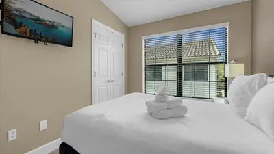 a bedroom with a white bed with a stuffed animal on it at Florida Getaway - Renovated TownHome by Disney! in Orlando