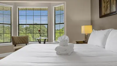 a bedroom with a white bed with towels on it at Florida Getaway - Renovated TownHome by Disney! in Orlando