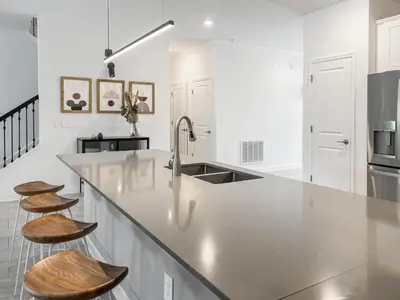 a kitchen with a large counter and two stools at Happily Ever Home, Your Family Dream Beyond Disney in Kissimmee