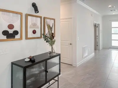 a living room with a black table and some paintings at Happily Ever Home, Your Family Dream Beyond Disney in Kissimmee