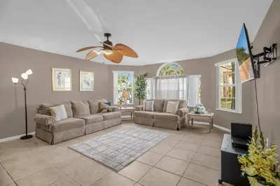 a living room with two couches and a ceiling fan at Ground Level Condo with Garden Patio in Kissimmee