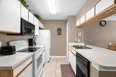 a kitchen with a sink and a refrigerator at Ground Level Condo with Garden Patio in Kissimmee
