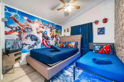 a bedroom with two beds and a superhero mural at Beautiful 5BR 4 baths Themed home near Disney and Universal, Private Pool, Gameroom, baby Crib and more in Kissimmee