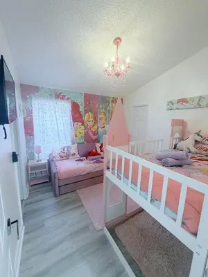 a bedroom with two bunk beds and a chandelier at Beautiful 5BR 4 baths Themed home near Disney and Universal, Private Pool, Gameroom, baby Crib and more in Kissimmee