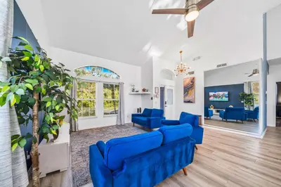 a living room with blue couches and a tree at Beautiful 5BR 4 baths Themed home near Disney and Universal, Private Pool, Gameroom, baby Crib and more in Kissimmee