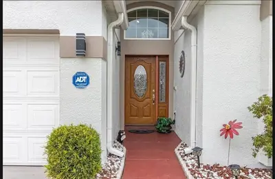 a house with a brown door and a garage at Tropical Escape by Shine Villas 244 villa in Kissimmee