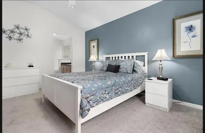 a bedroom with a white bed and a blue wall at Tropical Escape by Shine Villas 244 villa in Kissimmee