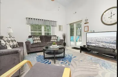 a living room with a couch and a tv at Tropical Escape by Shine Villas 244 villa in Kissimmee