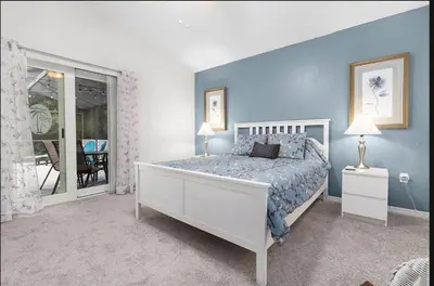 a bedroom with a large bed with blue walls at Tropical Escape by Shine Villas 244 villa in Kissimmee