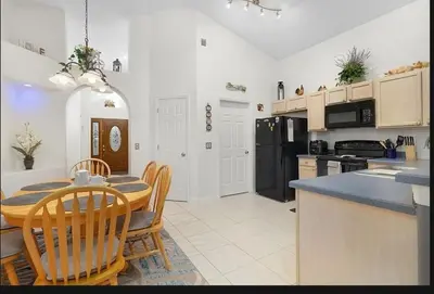 a kitchen and dining room with a table and chairs at Tropical Escape by Shine Villas 244 villa in Kissimmee