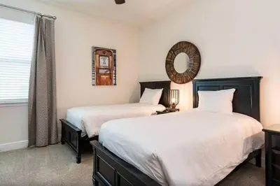 two beds in a bedroom with a mirror and a window at 361 Pendant ct in Orlando
