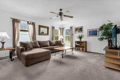 a living room with a couch and a ceiling fan at Bluelakeview Luxury Villa with Private Pool & Spa plus Lake Views, BBQ, Games Room in Orlando