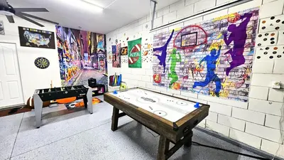 a room with a ping pong table in front of a wall at Bluelakeview Luxury Villa with Private Pool & Spa plus Lake Views, BBQ, Games Room in Orlando