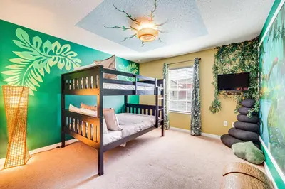 a bedroom with a bunk bed and a tv at Resort Perks and Private Pool Kissimmee Retreat! in Kissimmee
