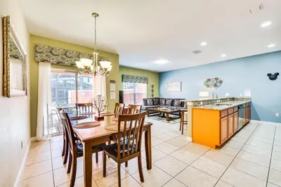 a dining room and living room with a table and chairs at Resort Perks and Private Pool Kissimmee Retreat! in Kissimmee