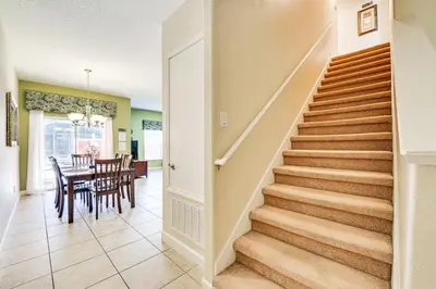 a staircase in a home with a table and chairs at Resort Perks and Private Pool Kissimmee Retreat! in Kissimmee