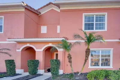 a pink house with palm trees in front of it at Resort Perks and Private Pool Kissimmee Retreat! in Kissimmee