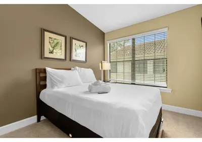 a bedroom with a large white bed with a window at Your Summer Getaway Awaits - Townhome by Disney! in Orlando