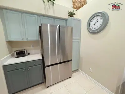 a kitchen with a refrigerator and a clock on the wall at 35 - Relax & Play 4-Bed Villa with Pool & Game Room Minutes to Disney in Orlando