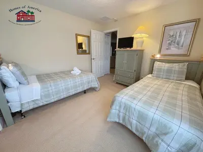 a bedroom with two beds and a tv in it at 35 - Relax & Play 4-Bed Villa with Pool & Game Room Minutes to Disney in Orlando