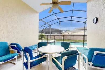 a patio with a table and chairs and a pool at Disney 15 Min - Sleeps 8 - Private Pool in Kissimmee