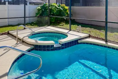a small swimming pool with blue tiles in a backyard at Disney 15 Min - Sleeps 8 - Private Pool in Kissimmee
