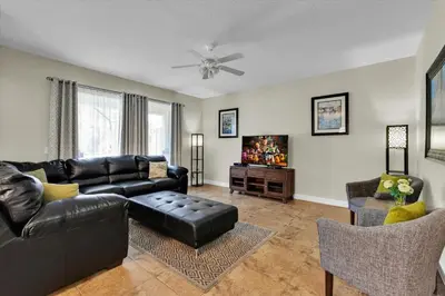 a living room with a black leather couch and a tv at 2920 Banana Palm in Kissimmee